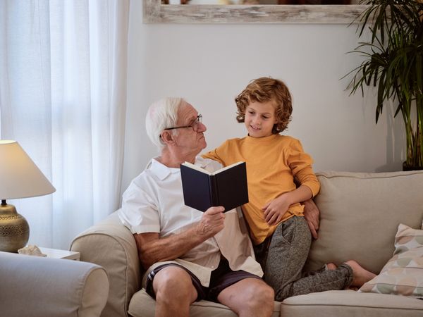 Grandfather with boy reading book