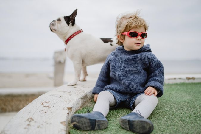 Funny kid with dog on beach