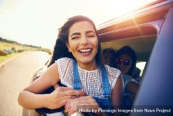 Smiling woman leaning out of car window 5q7GKb