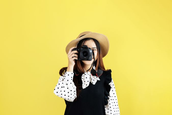 Young Woman Traveler with Straw Hats is taking Images Photo with DSLR Camera