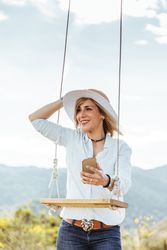 Happy female with hat next to a swing