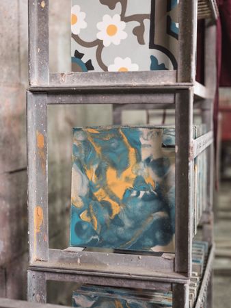 Colorful glaze tiles on shelves in workshop
