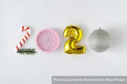 2020 spelled with different decorative objects; candy cane, clock, balloon and disco ball 0JgGl5