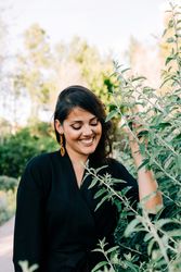 Smiling female looking out of green bushes