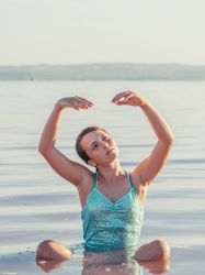 Teenage girl sitting in fresh water in sunny day