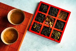 Cup of green tea with box of loose leaf options
