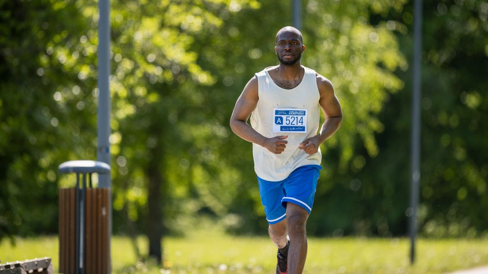 Portrait of a Young Black Male Jogger Running in a Park on a Health Trail.