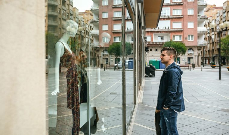 Man looking shop window to buy a gift