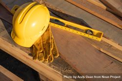 Abstract of Constrcution Hard Hat, Gloves and Level Resting on Wood Planks 5wXRg9