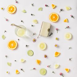 Colorful pattern made of orange, lemon, lime and flowers with lemonade and vintage book with key