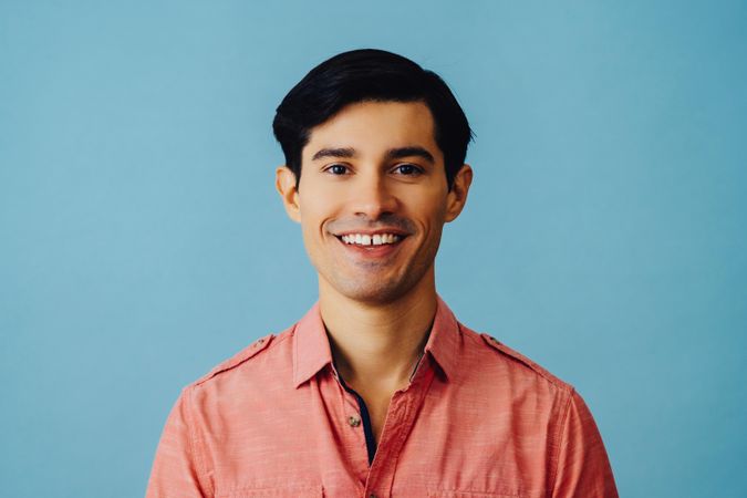 Portrait of happy Hispanic male smiling in pink shirt