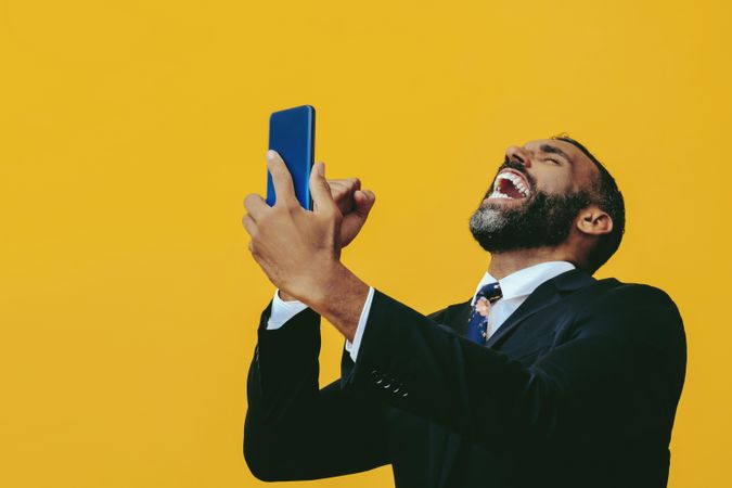 Animated Black businessman in suit laughing at smartphone screen