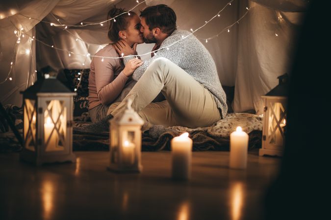 Couple sitting on bed kissing each other