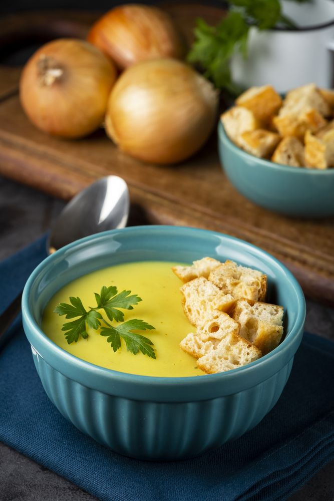 Bowl with onion soup and croutons on the table.