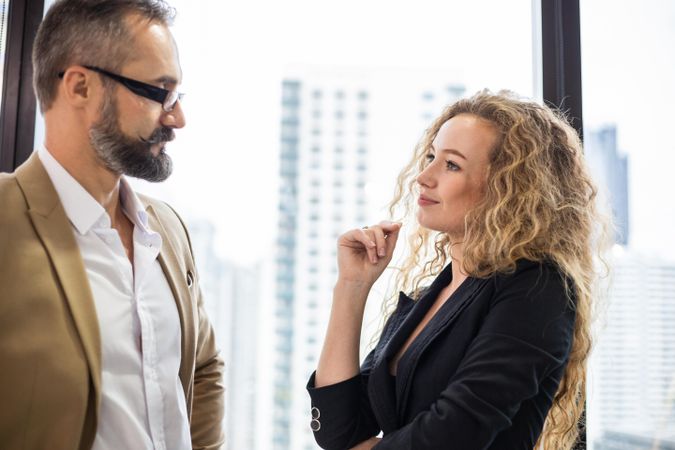 Two business people discussing work in bright office