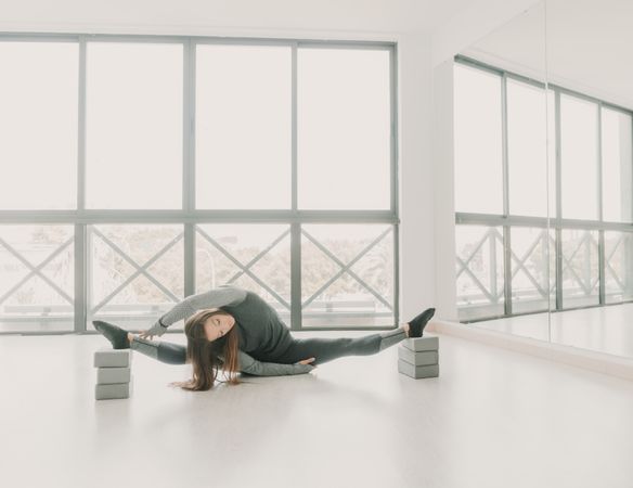 Flexible woman stretching in studio