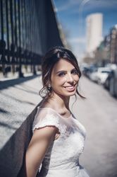 Smiling young fiancee near fence on street
