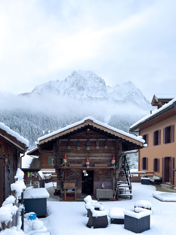 Garden gnomes on snowy wooden shed in the Alps