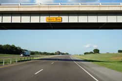 Bridge above road with height mentioned on board