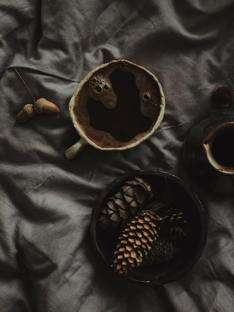 Top view of Turkish coffee surrounded by pine cones on grey sheets