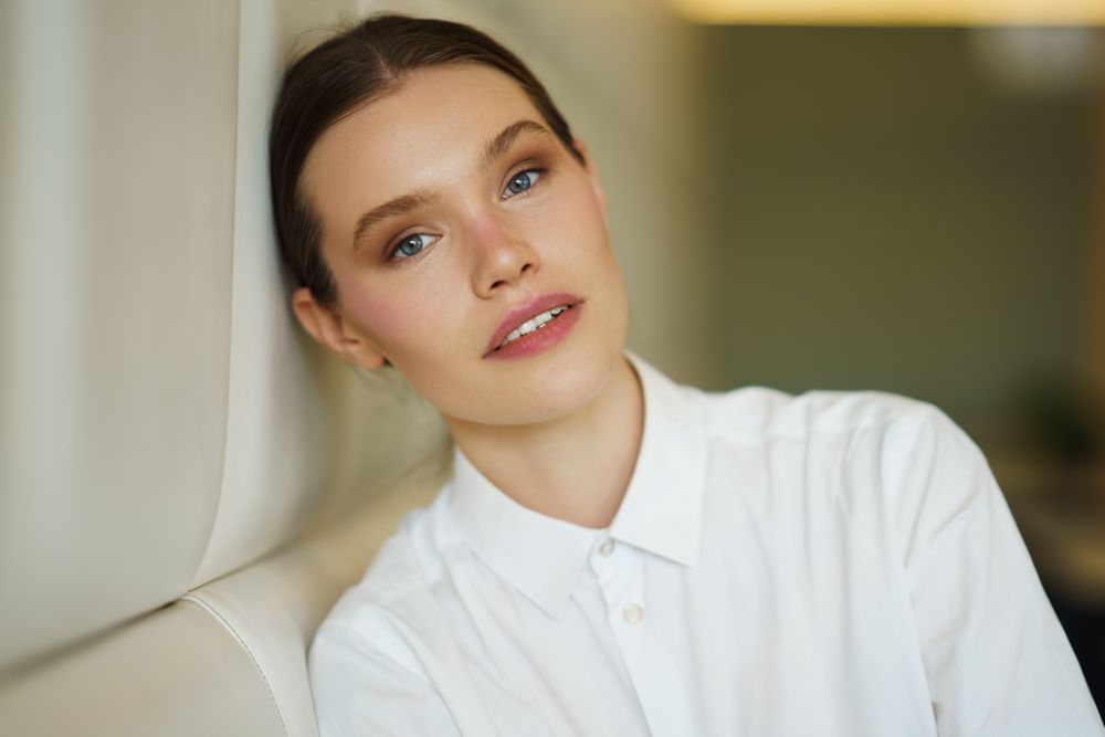 Woman leaning against beige wall