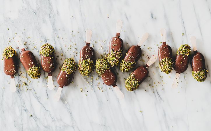 Ice cream chocolate pistachio popsicles, light background, top view