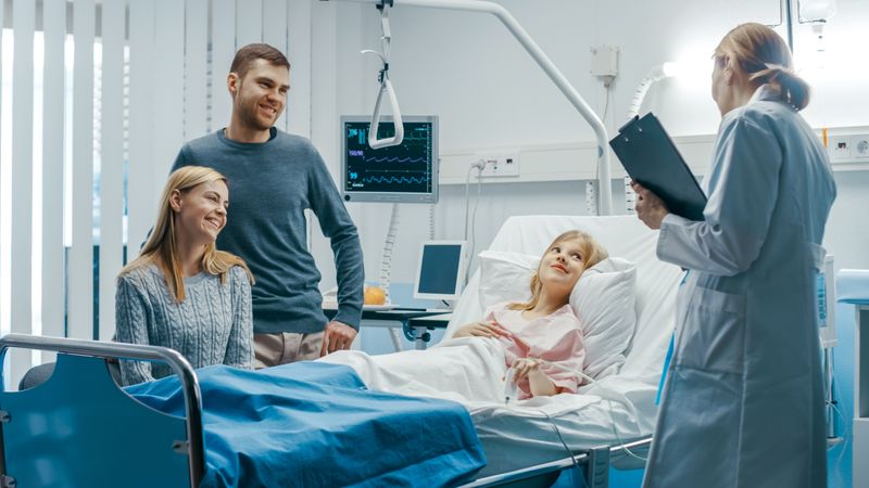 Recovering Little Girl Lies on a Bed In the Hospital, Friendly Doctor Talk, Mother Sits with Father Beside Bed.