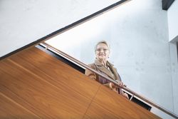 Smiling older woman looking over the escalator
