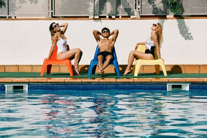 a group of young models by the pool with sunglasses