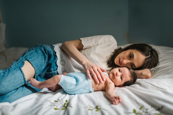 Mother and baby lying on bed