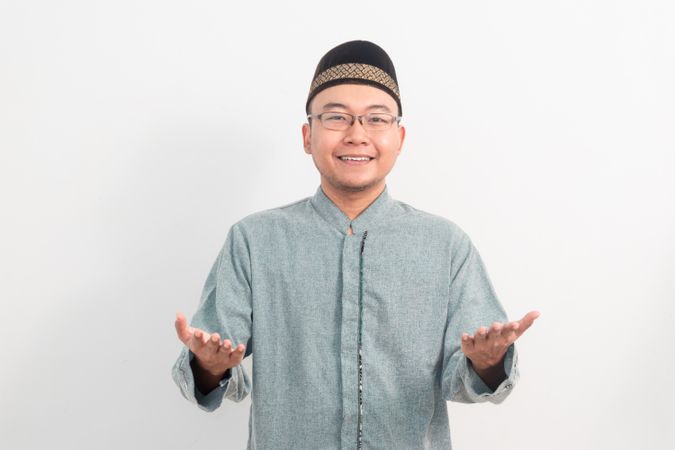 Asian Muslim man smiling doing greeting pose during Ramadan