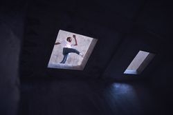 Young man practicing breakdance in unfinished building