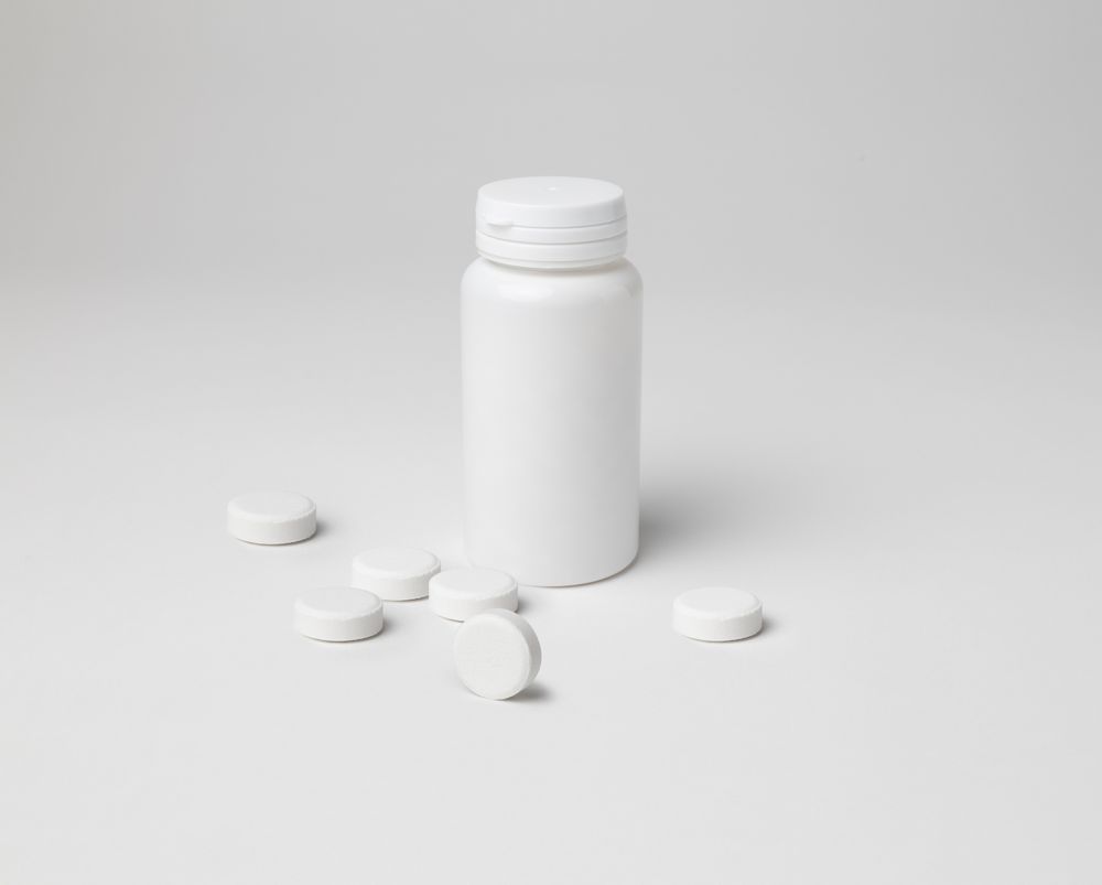 Mockup of a closed aspirin bottle, small size, on background with copyspace