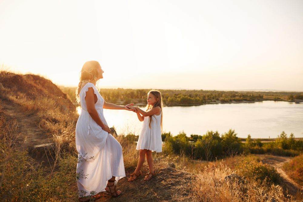 A little girl pulls her mother by the hand near lake