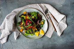 Organic vegetable salad on counter with napkin and cutlery