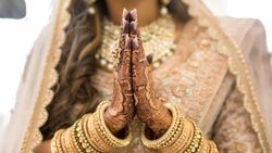 Woman in golden cultural outfit and jewelry with Mehndi tattoo
