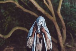 Woman holding blue metallic sheet over her head