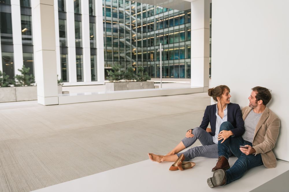 Businesspeople hugging and using smartphone on street