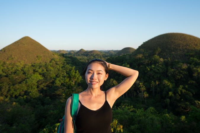Happy woman standing on observation deck on hill
