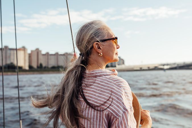 Glamorous older woman enjoying the view from a sailboat