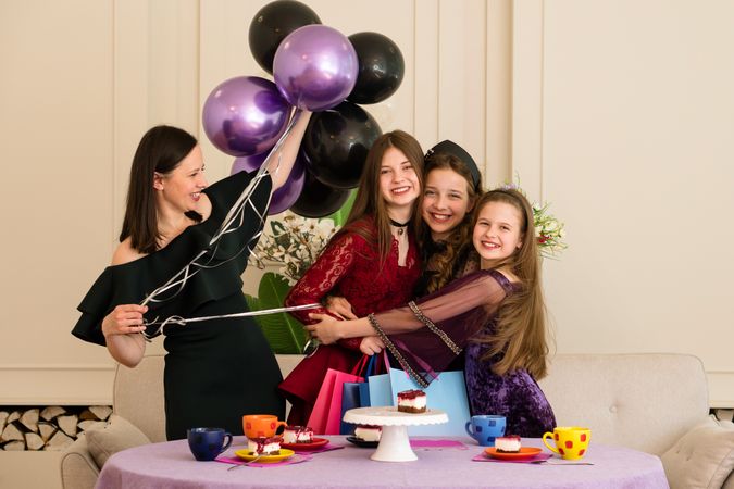 Teen with woman and two young girls. Birthday Party