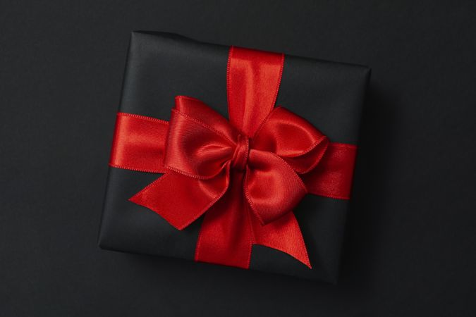 Gift box with red bow on dark background