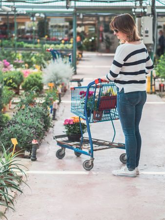 Female customer choosing flowers in greenhouse