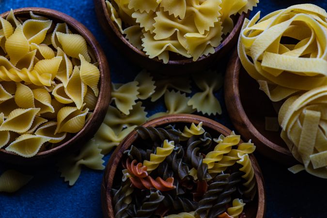 Top view of bowls of dry Italian pasta