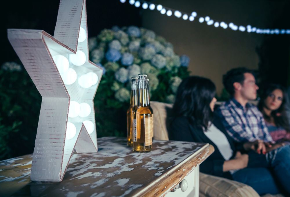 Star lamp with light bulbs over table with beer bottles