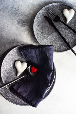 Place setting for St. Valentine Day with hearts on grey plates