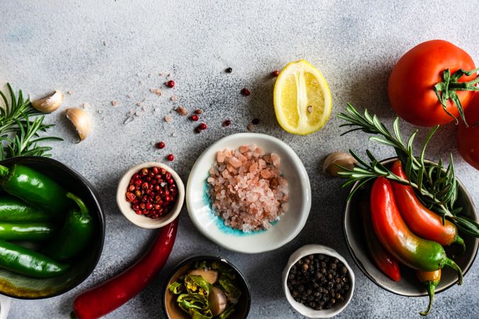 Top view of seasoning with tomatoes, seasoning, garlic & herbs on marble counter