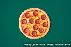 Pizza salami isolated on a green background 432AzZ