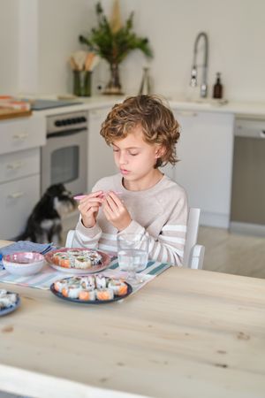 Child having tasty lunch in kitchen at home