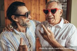 Happy older men wearing funny sunglasses making funky gestures 5wLLm4